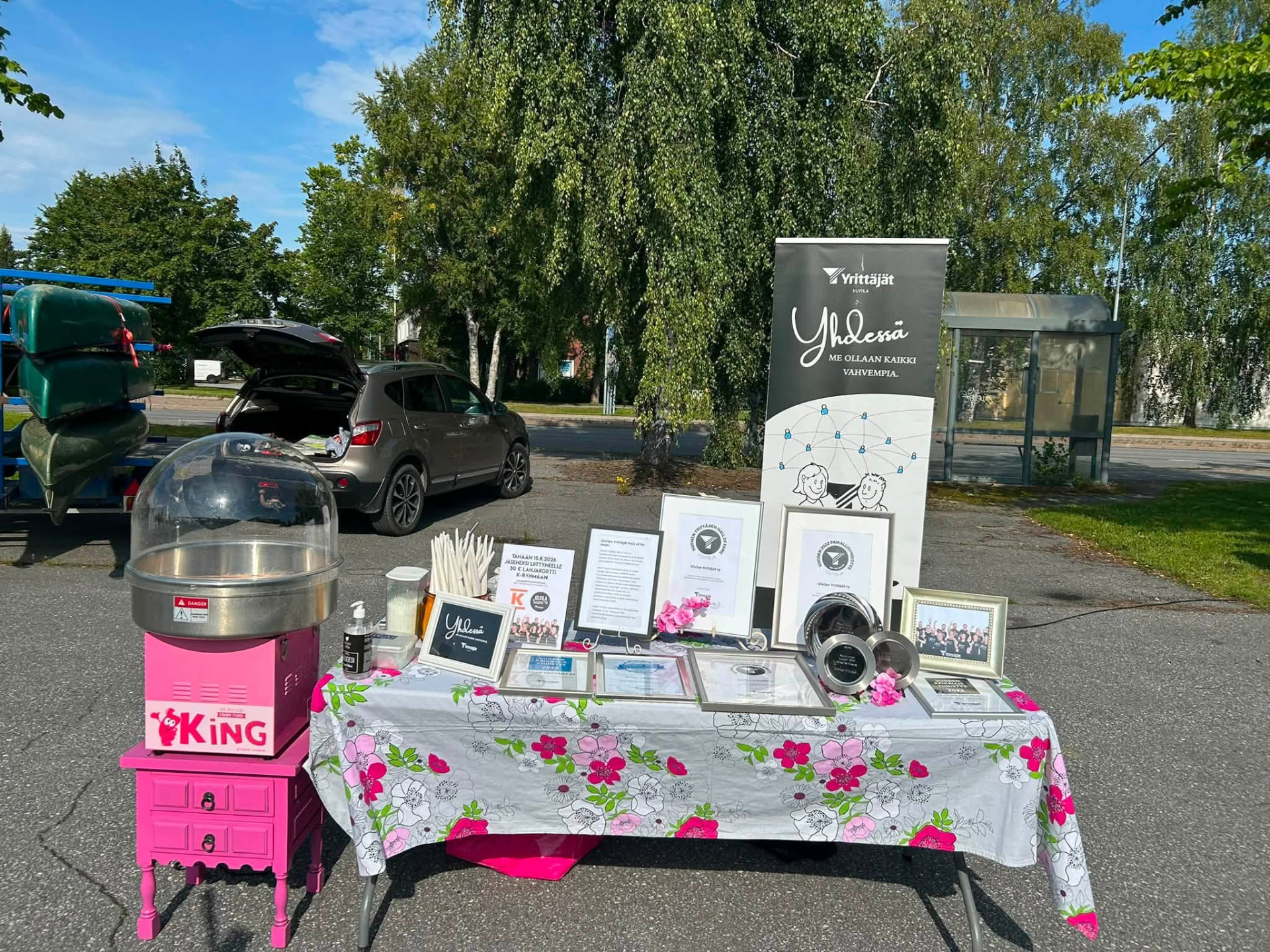 Association information table with framed awards and certificates at an outdoor event